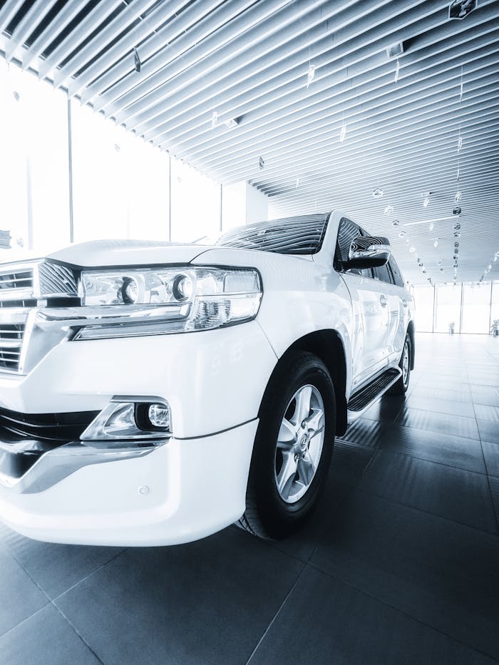 pexels-photo-17744273 White SUV displayed in a contemporary dealership with modern architecture, highlighting sleek automotive design.