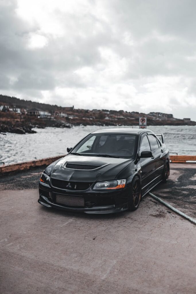 pexels-photo-9846165 Black car parked on a waterfront, capturing a blend of modern automotive design and natural beauty.